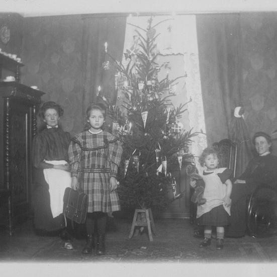 En familie i deres stue med juletræ.