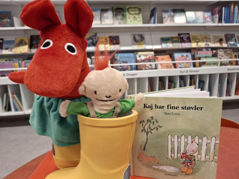 Foto af en dukke og Kaj-bogen