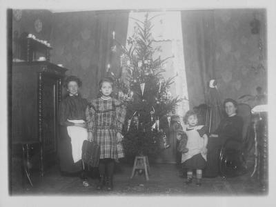 En familie i deres stue med juletræ.