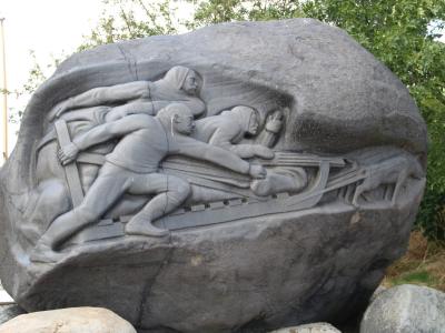 Relief på Langeliniemonumentet af slædeholdet, der viser deltagerne og hundene.