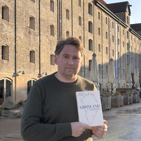 historikeren Jens Heinrich holder sin bog Grønland, han står foran Nordatlantens Brygge på Christianshavn.