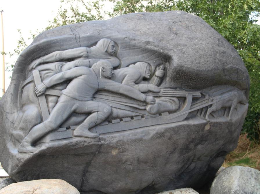 Relief på Langeliniemonumentet af slædeholdet, der viser deltagerne og hundene.