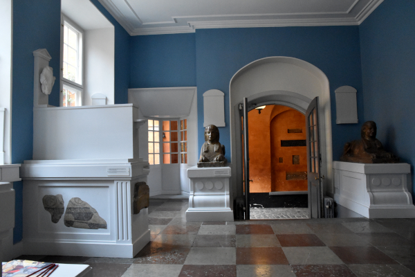 Blåmalet rum med forskellige historiske genstande indmuret og udstillet