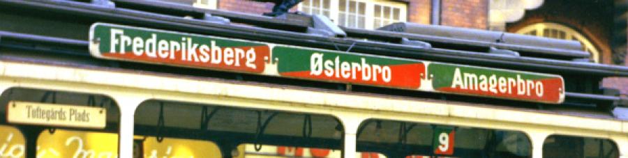 Foto af skile over vinduer på sporvogn med farverne grøn og rød og bydele i hvide teksttyper