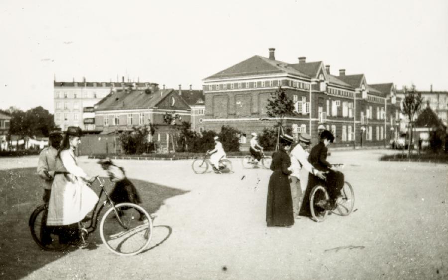 Kvinder træner cykling på pladsen foran kasernebygningen